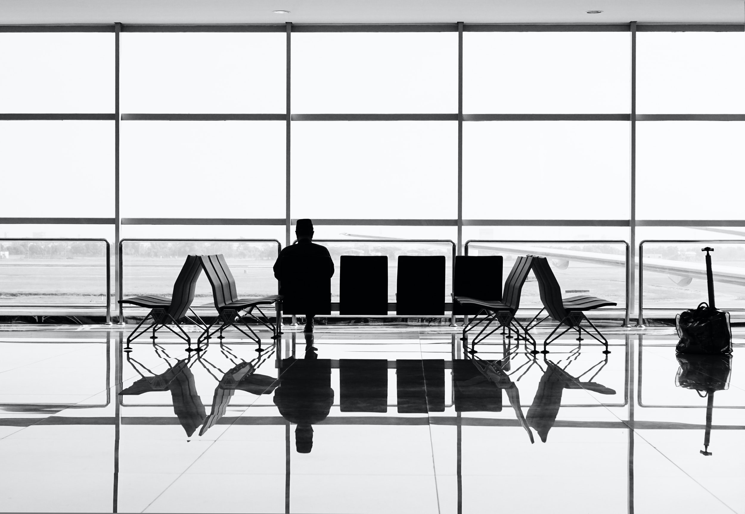 Silhouette of a person waiting at an airport, symbolizing travel to Brisbane for eye surgery.