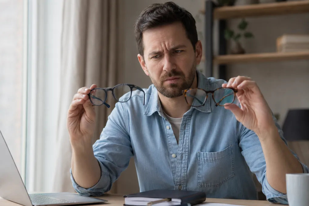 Patient comparing glasses that no longer correct their astigmatism fully