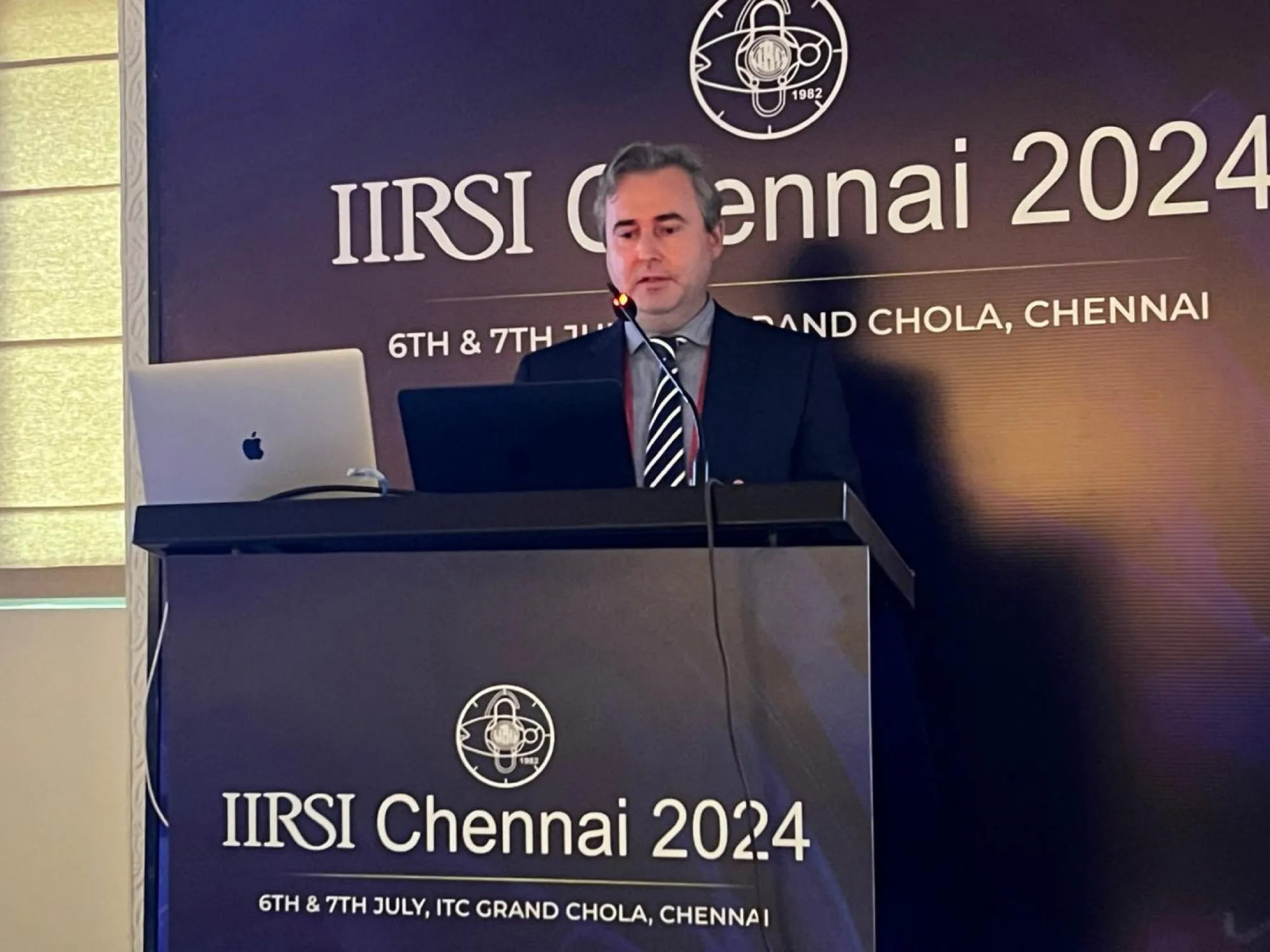Dr David Gunn presenting at the IIRSI 2024 convention podium at the ITC Grand Chola, Chennai.
