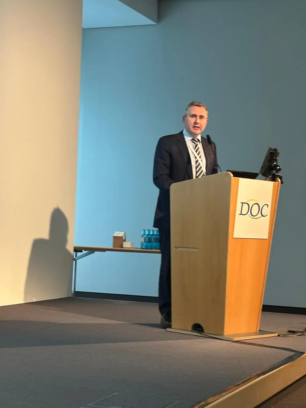 Dr. Gunn delivers the prestigious Ridley Lecture on CAIRS at the German Ophthalmic Society (DOC) meeting from a podium.