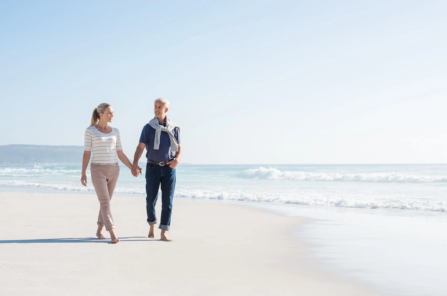 Married couple walking on the beach