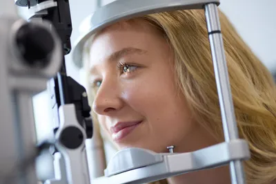 Young woman undergoing an eye examination with a slit lamp, preparing for laser eye surgery consultation in Brisbane.