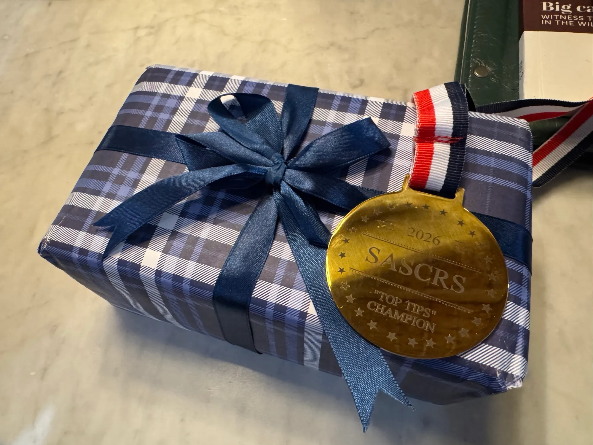 The SASCRS 2026 Top Tips Champion medal awarded to Dr David Gunn, engraved 2026 SASCRS Top Tips Champion on a red, white and blue ribbon.